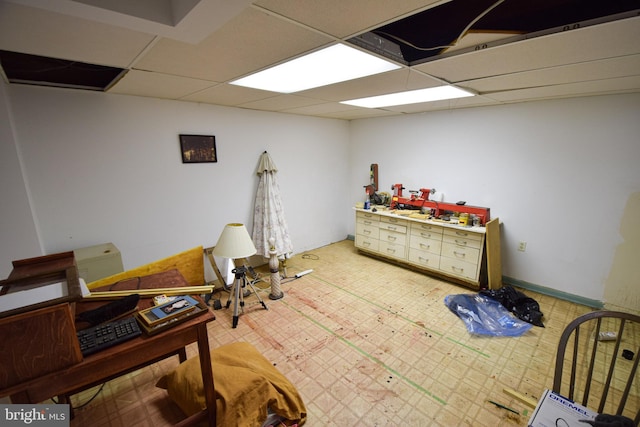 living area with a drop ceiling