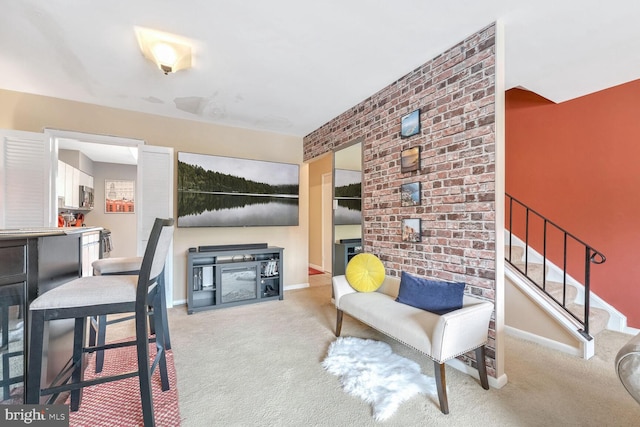 sitting room featuring light carpet and brick wall