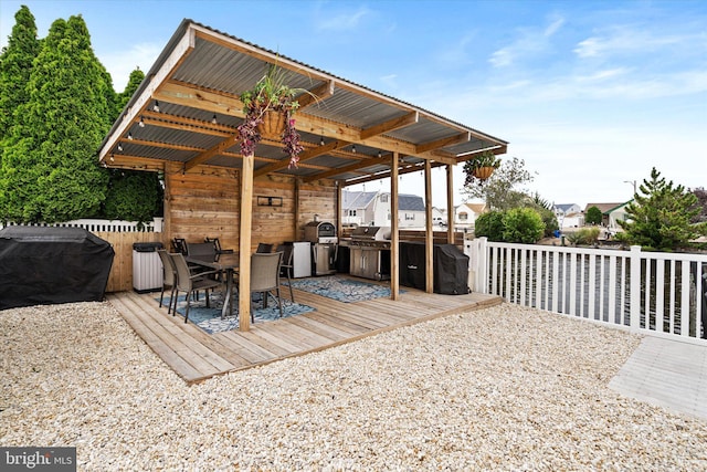 wooden terrace with an outdoor kitchen and grilling area