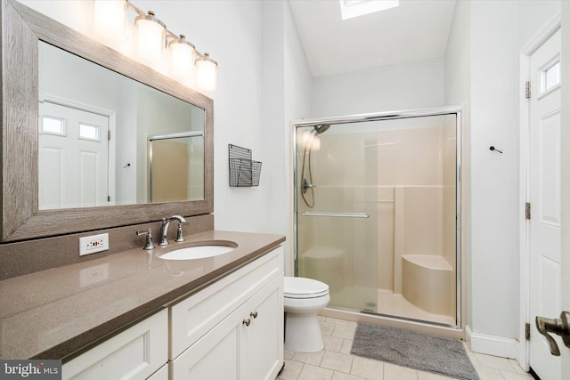 bathroom with tile patterned flooring, toilet, a shower with door, and vanity