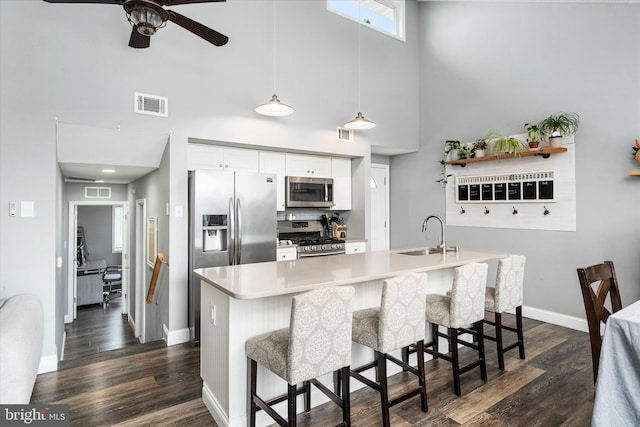 kitchen with white cabinets, a breakfast bar area, appliances with stainless steel finishes, and sink