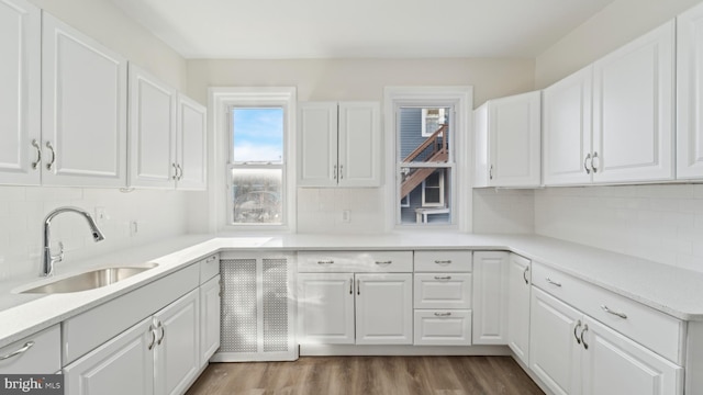 kitchen with sink, white cabinets, and backsplash