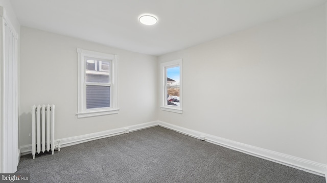 carpeted empty room with radiator heating unit