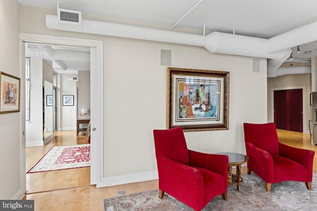 sitting room with wood-type flooring