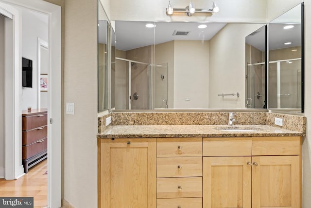 bathroom with vanity, hardwood / wood-style flooring, and walk in shower