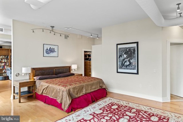 bedroom with wood-type flooring and rail lighting