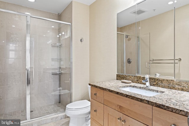 bathroom featuring vanity, toilet, and a shower with door