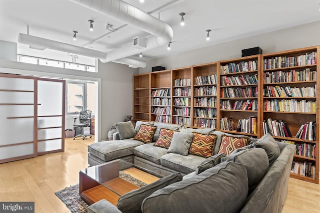 living area with track lighting and light hardwood / wood-style floors