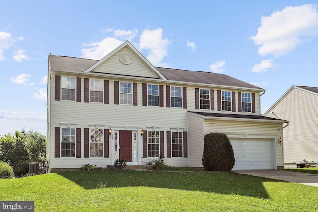 view of front of property with a front yard, cooling unit, and a garage