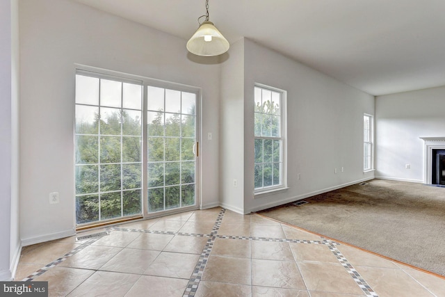 unfurnished living room with a wealth of natural light and light tile patterned flooring