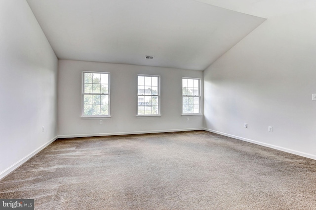 empty room featuring carpet floors and vaulted ceiling