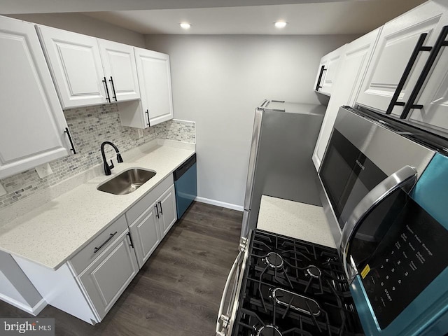 kitchen featuring sink, white cabinets, dark wood-type flooring, decorative backsplash, and stainless steel appliances