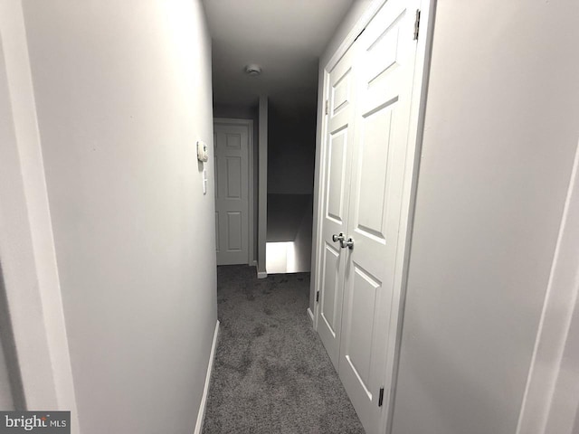 hall featuring dark carpet