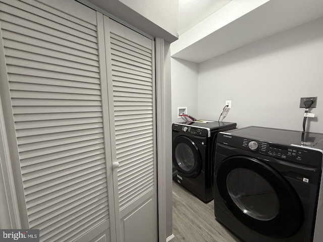 laundry area featuring light hardwood / wood-style floors and washer and dryer