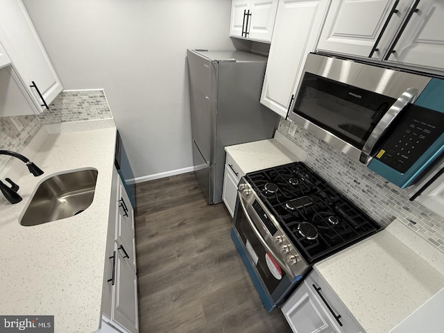 kitchen with white cabinetry, dark hardwood / wood-style flooring, stainless steel appliances, decorative backsplash, and sink