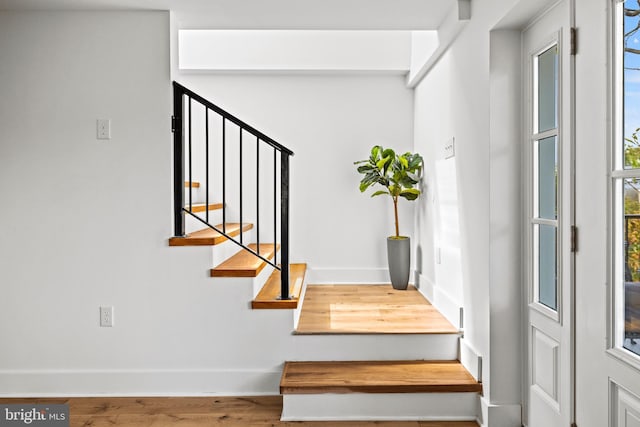 stairs featuring hardwood / wood-style floors