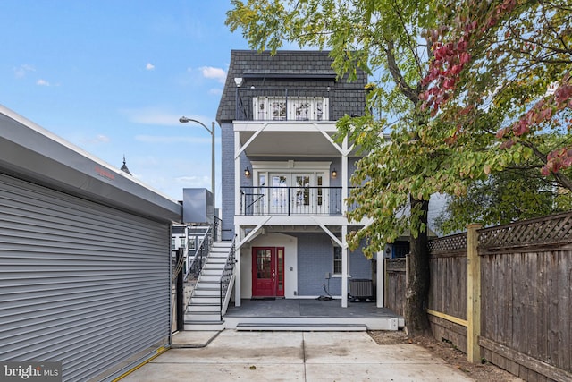 view of front of property with a balcony and central AC unit