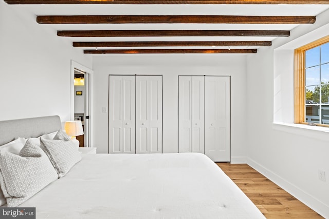 bedroom with wood-type flooring and beamed ceiling