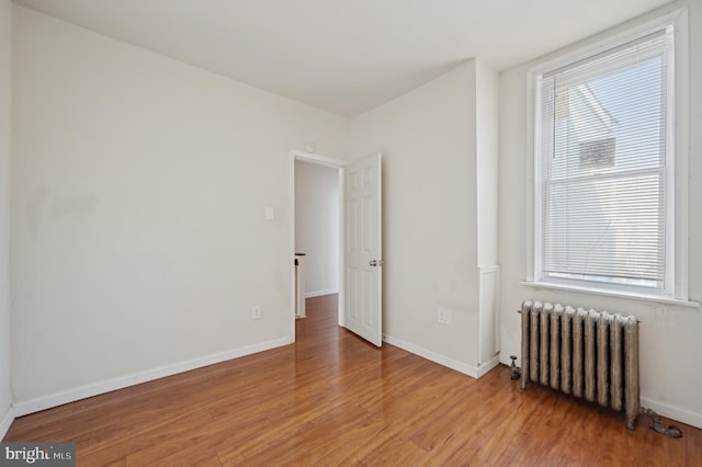 empty room featuring radiator and wood-type flooring