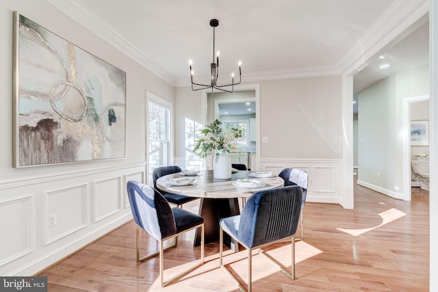 dining area featuring a notable chandelier, crown molding, and light hardwood / wood-style flooring