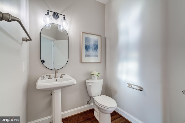 bathroom featuring wood-type flooring, toilet, and sink