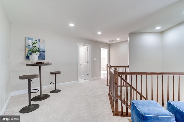 hallway featuring light colored carpet