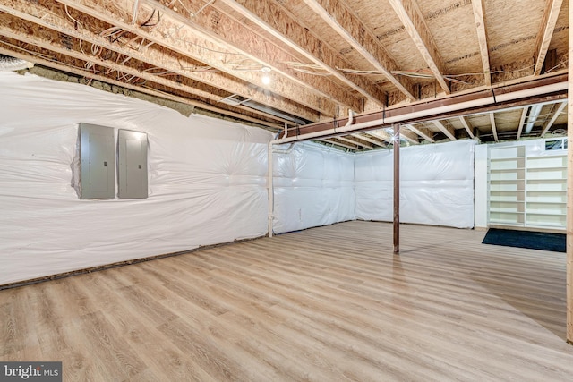 basement with wood-type flooring and electric panel