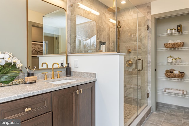 bathroom featuring a shower with door and vanity