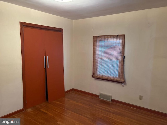 unfurnished bedroom with hardwood / wood-style flooring and a closet