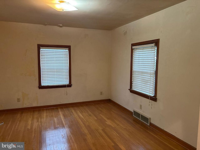 spare room featuring light hardwood / wood-style floors and plenty of natural light