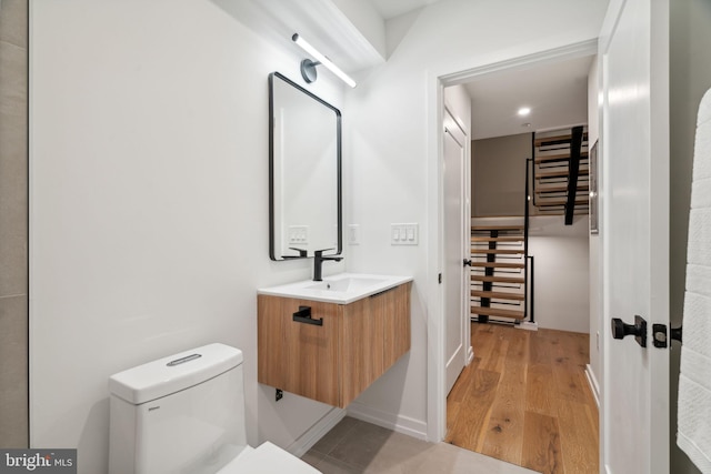 bathroom featuring hardwood / wood-style flooring, toilet, and vanity