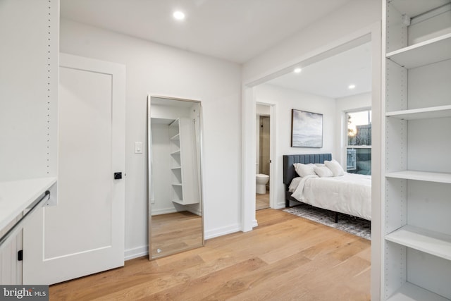 unfurnished bedroom with a walk in closet and light hardwood / wood-style floors