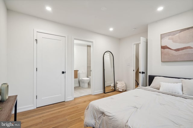 bedroom featuring light wood-type flooring and ensuite bath