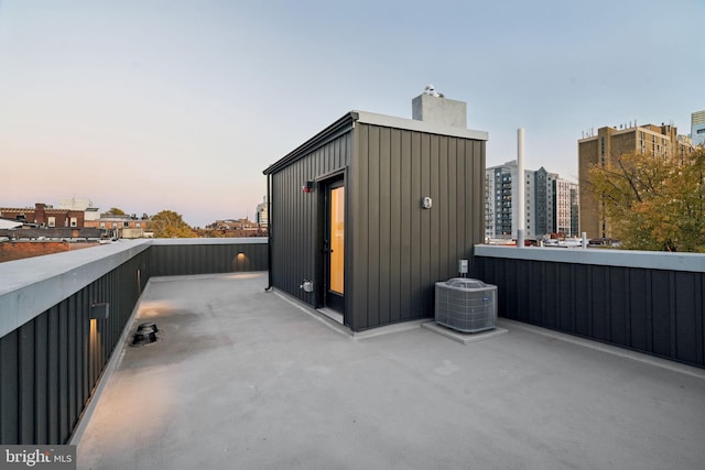 patio terrace at dusk with a balcony and central air condition unit