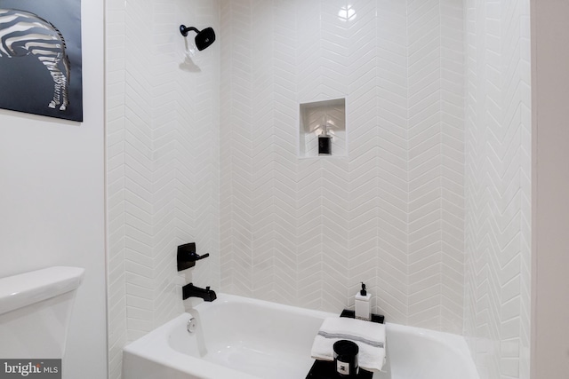 bathroom featuring tiled shower / bath combo and toilet