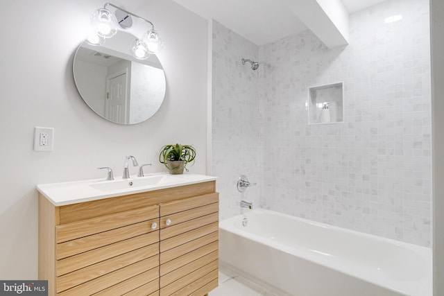 bathroom featuring tiled shower / bath and vanity