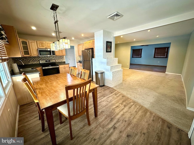 dining room with sink and light wood-type flooring