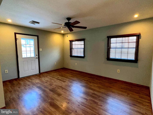 interior space featuring ceiling fan, a wealth of natural light, dark hardwood / wood-style floors, and a textured ceiling