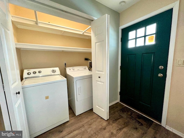 clothes washing area featuring hardwood / wood-style flooring and washer and dryer