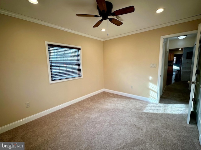 carpeted empty room with ceiling fan and ornamental molding