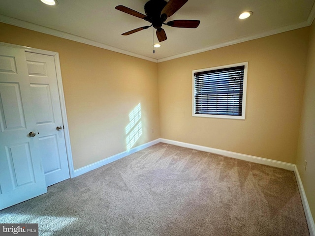 spare room featuring carpet floors, a wealth of natural light, crown molding, and ceiling fan