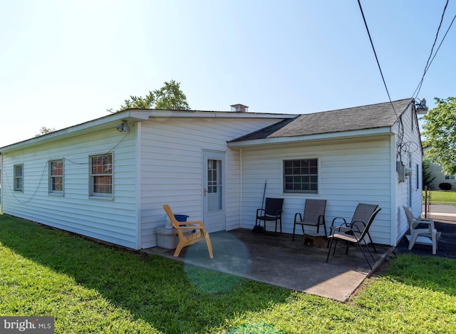 rear view of house featuring a patio and a lawn