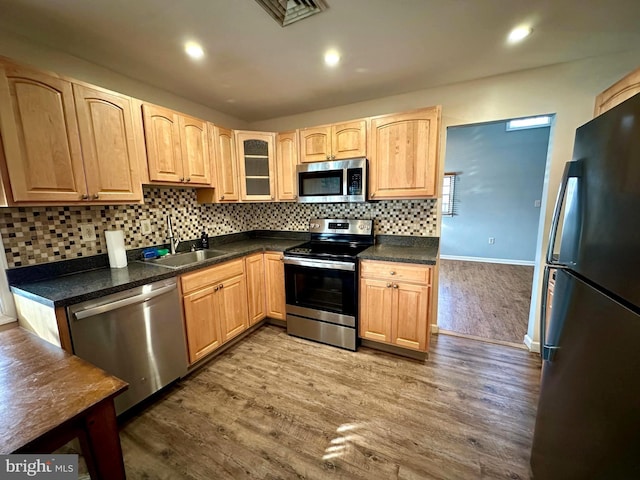 kitchen with sink, light brown cabinets, wood-type flooring, and appliances with stainless steel finishes