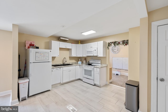 kitchen featuring white cabinets, light wood-type flooring, sink, and white appliances