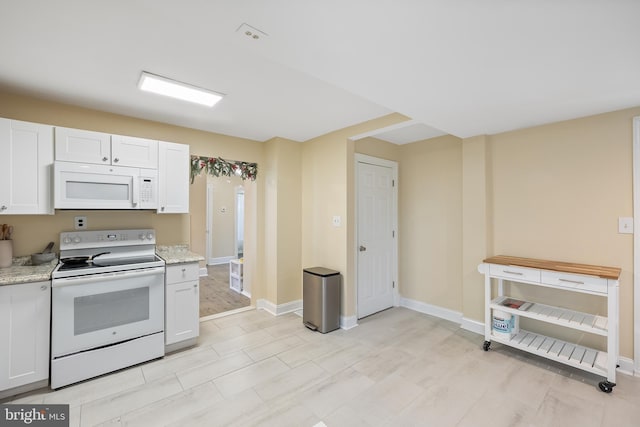 kitchen featuring light stone counters, white appliances, white cabinets, and light hardwood / wood-style flooring