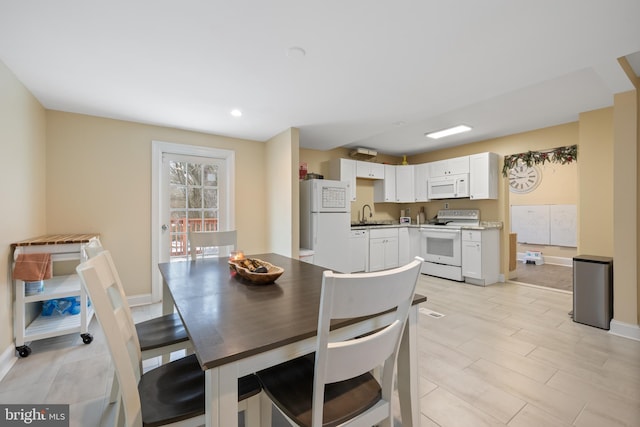 dining area with sink and light hardwood / wood-style flooring