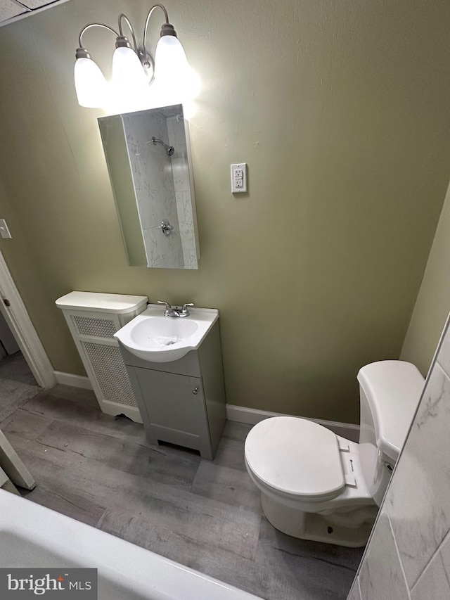 bathroom with toilet, hardwood / wood-style flooring, and vanity