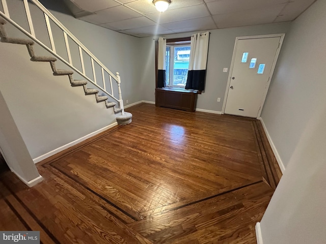 foyer with a paneled ceiling and dark hardwood / wood-style floors