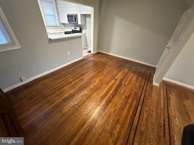 unfurnished living room with dark hardwood / wood-style flooring