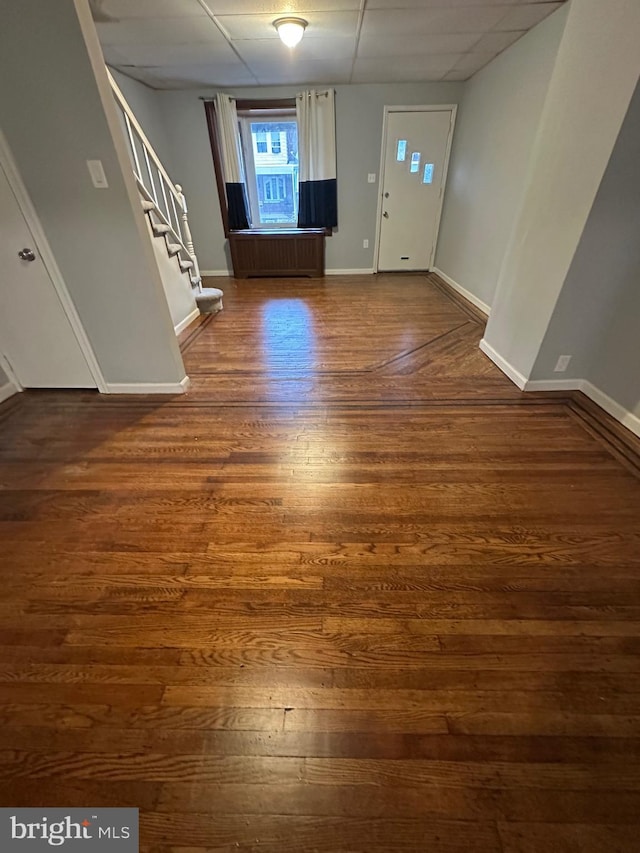 foyer entrance with dark hardwood / wood-style flooring and a drop ceiling